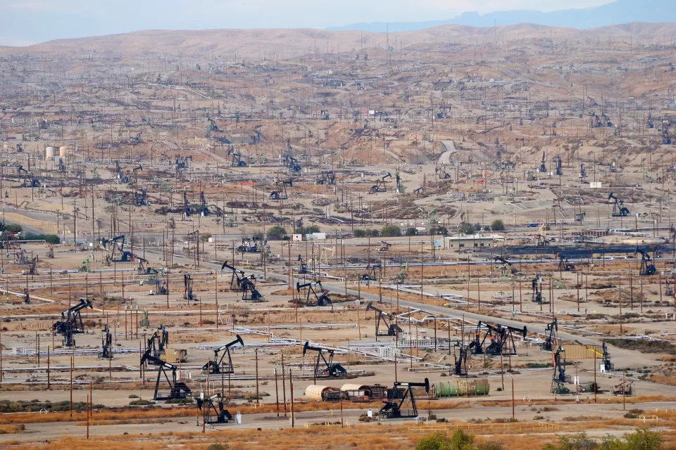 View of vast oil drilling field with black oil derricks near Bakersfield, California